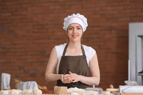 Θηλυκό baker μαγείρεμα ψωμάκια στην κουζίνα — Φωτογραφία Αρχείου