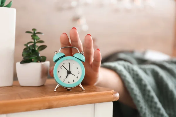 Sleepy woman turning off alarm clock in morning — Stock Photo, Image