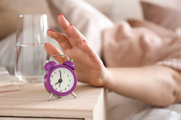 Donna assonnata che spegne la sveglia al mattino — Foto Stock