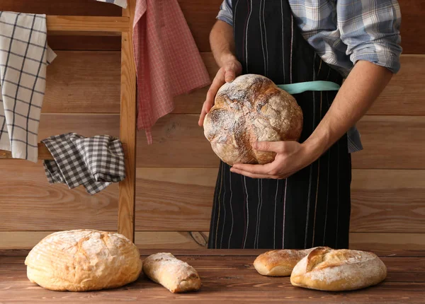 Man with freshly baked bread in kitchen