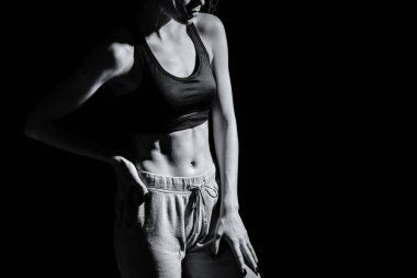 Sportif genç kadın koyu arka plan üzerinde siyah beyaz fotoğrafı
