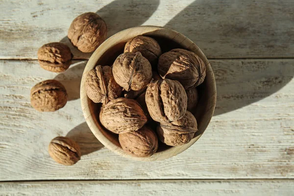 Bowl with tasty walnuts on light table — Stock Photo, Image