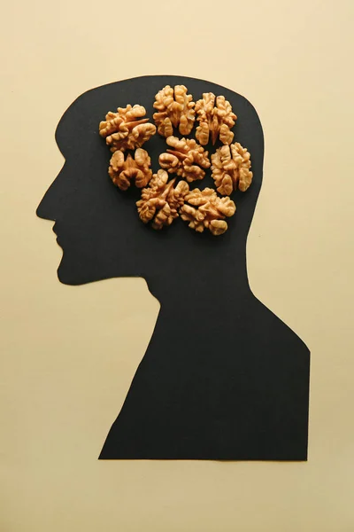 Human silhouette with shelled walnuts on light background — Stock Photo, Image