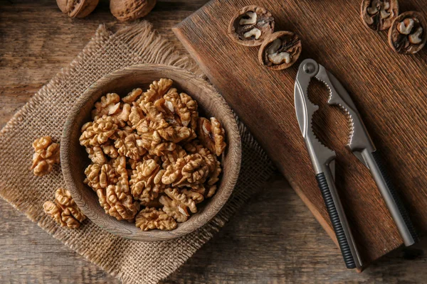 Bowl with tasty walnuts on wooden table — Stock Photo, Image