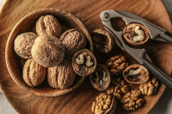 Noci saporite con schiaccianoci sul piatto, primo piano — Foto Stock