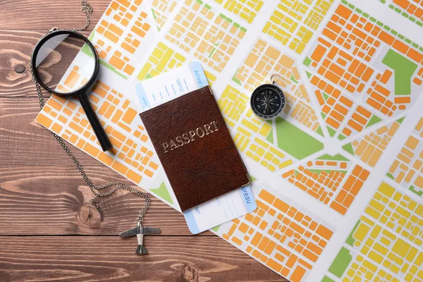 Map with passport, compass and magnifier on wooden table — Stock Photo, Image