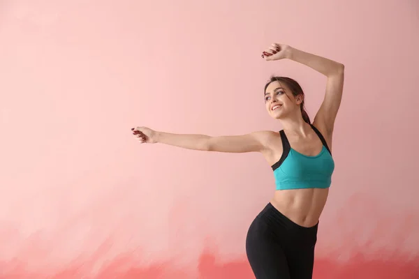 Sportliche junge Frau auf farbigem Hintergrund — Stockfoto