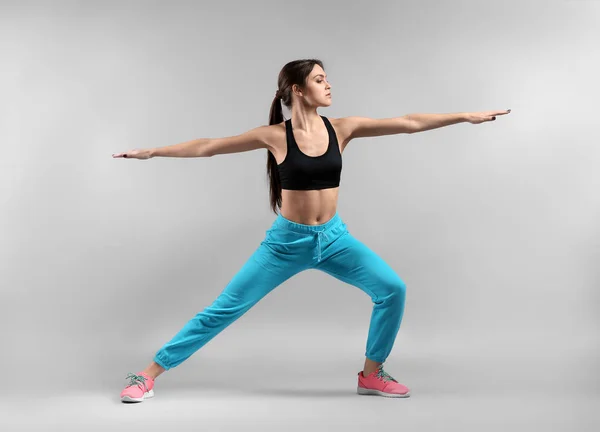 Sporty young woman on light background — Stock Photo, Image