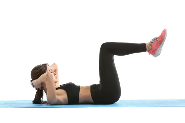 Sporty young woman doing crunches against white background — Stock Photo, Image