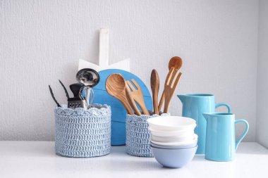 Mutfak eşyaları beyaz duvarının yakınında tablo ayarlama