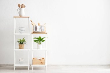 Raflar mutfak eşyaları yakınındaki beyaz duvar ile