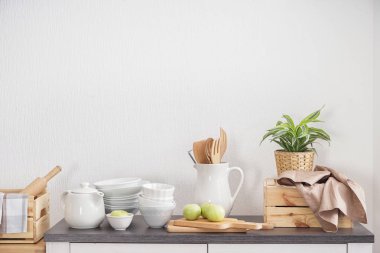 Beyaz duvar yakınındaki masada mutfak eşyaları