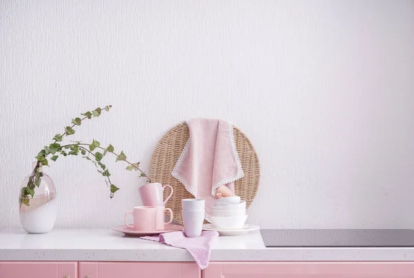 Set of tableware and modern stove in kitchen — Stock Photo, Image