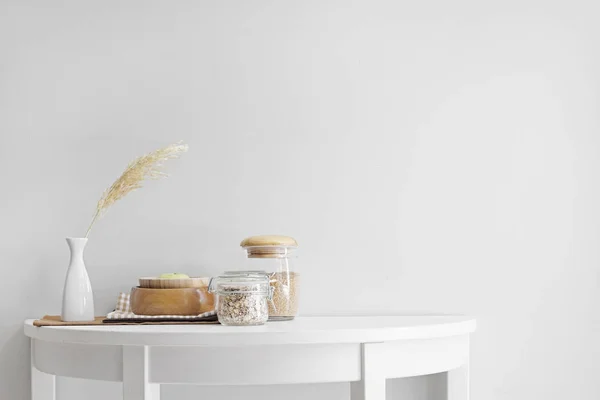 Kitchenware on table near white wall — Stock Photo, Image