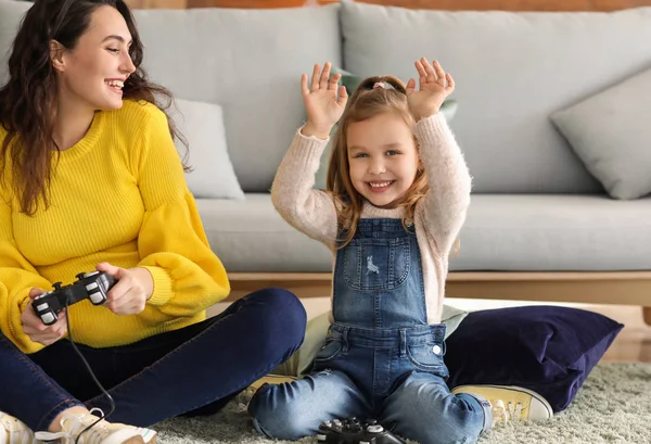 Pregnant mother with little daughter playing video games at home — Stock Photo, Image