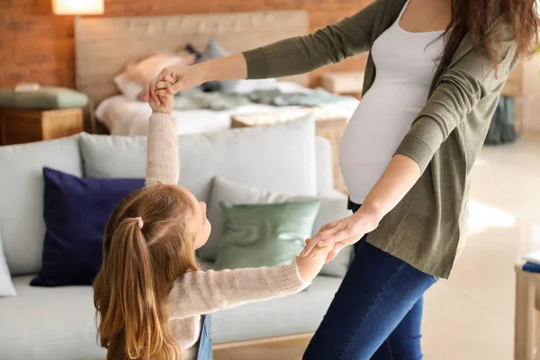 Zwangere moeder met dochtertje dansen thuis — Stockfoto