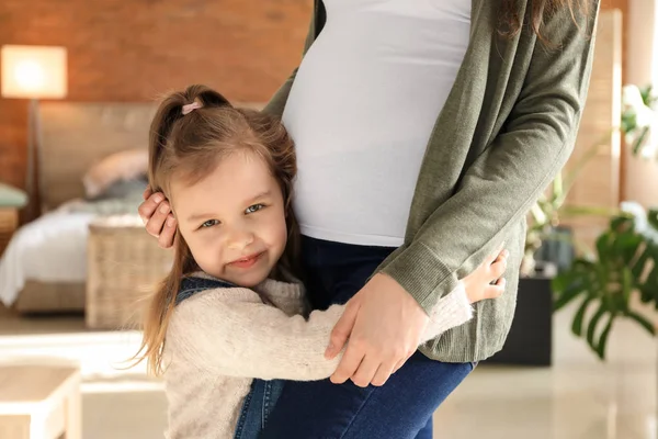 Meisje met zwangere moeder thuis — Stockfoto
