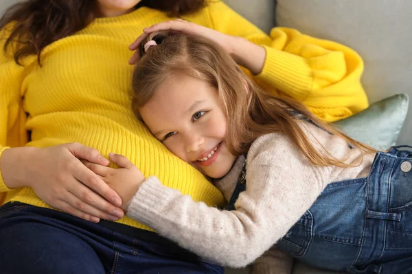 Meisje met zwangere moeder thuis — Stockfoto