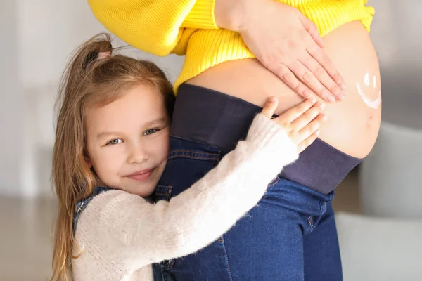 Meisje met zwangere moeder thuis — Stockfoto