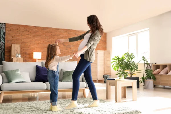 Pregnant mother with little daughter dancing at home — Stock Photo, Image