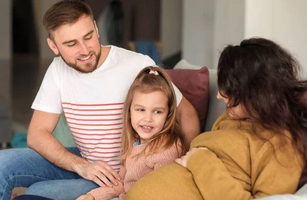 Happy family expecting baby resting at home