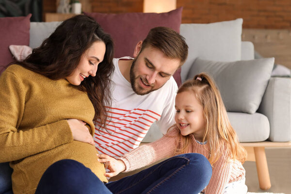 Happy family expecting baby resting at home