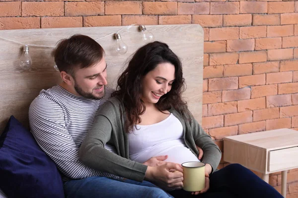 Ευτυχισμένο ζευγάρι έγκυος ξεκουράζονται στο σπίτι — Φωτογραφία Αρχείου