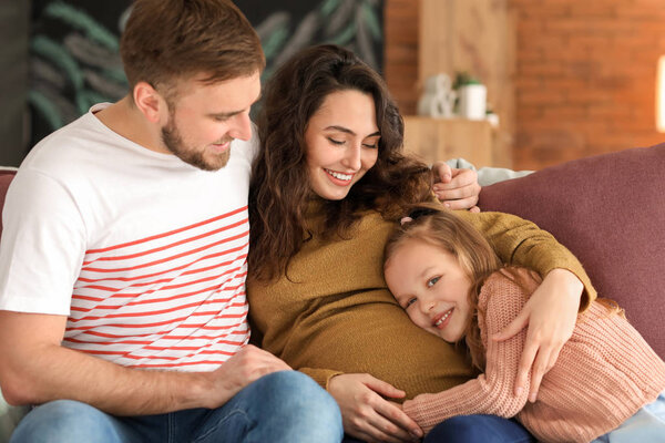 Happy family expecting baby resting at home