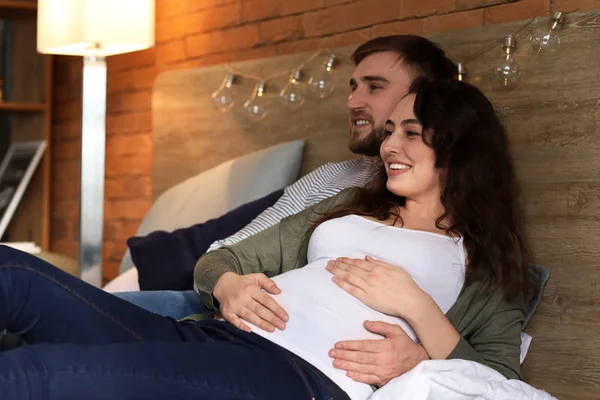 Glückliches schwangere Paar ruht sich zu Hause aus — Stockfoto
