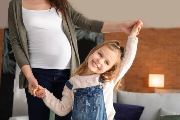 Zwangere moeder met dochtertje dansen thuis — Stockfoto