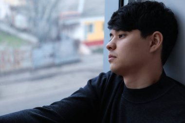 Pencere yanında otururken intiharı düşünme depresif genç adam