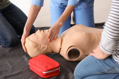 CPR ilk yardım eğitim kursu, manken üzerinde gösteren eğitmen
