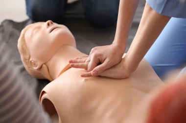 CPR ilk yardım eğitim kursu, manken üzerinde gösteren eğitmen