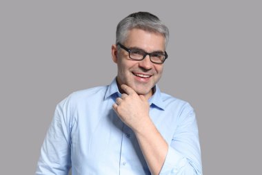 Yakışıklı olgun işadamı gri arka plan üzerinde