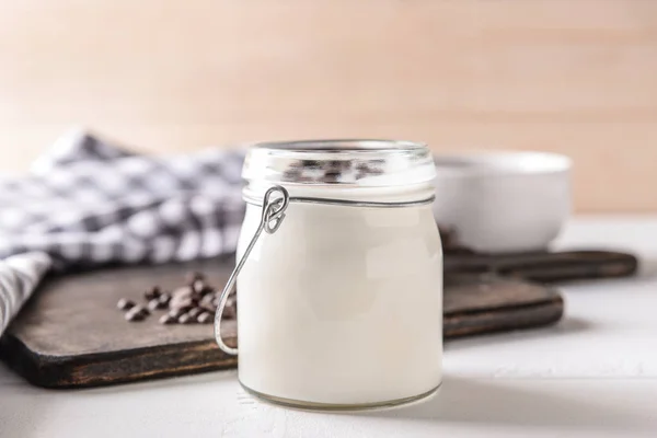 Jar with tasty yogurt and chocolate chips on white table — Stock Photo, Image