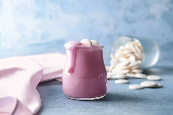 Tarro con sabroso yogur y chispas de chocolate en la mesa de color —  Fotos de Stock