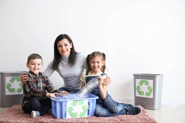 Familie sorteren van vuilnis in de buurt van witte muur. Concept van recycling — Stockfoto