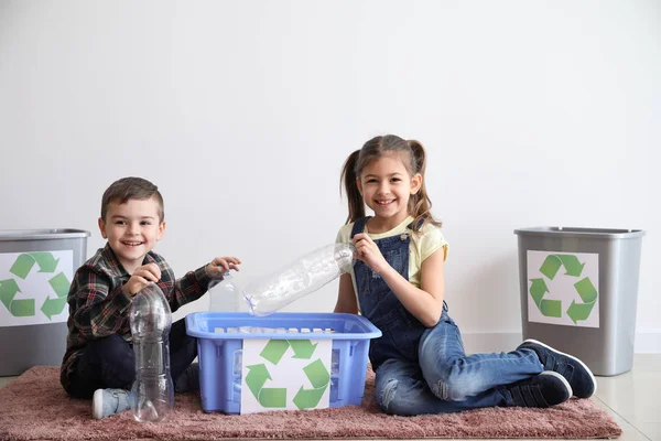 Little children sorting garbage near white wall. Concept of recycling — Stock Photo, Image