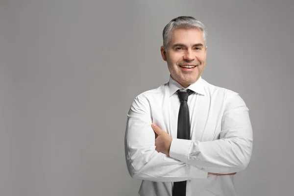 Guapo hombre de negocios maduro sobre fondo gris — Foto de Stock