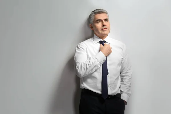 Handsome mature businessman on grey background — Stock Photo, Image