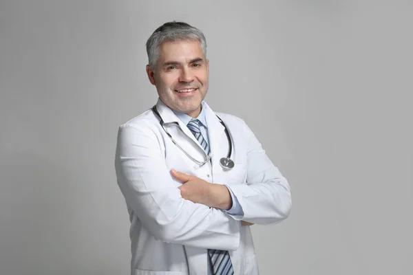 Medico maturo su sfondo grigio — Foto Stock