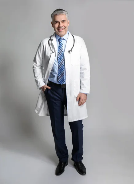 Mature doctor on grey background — Stock Photo, Image