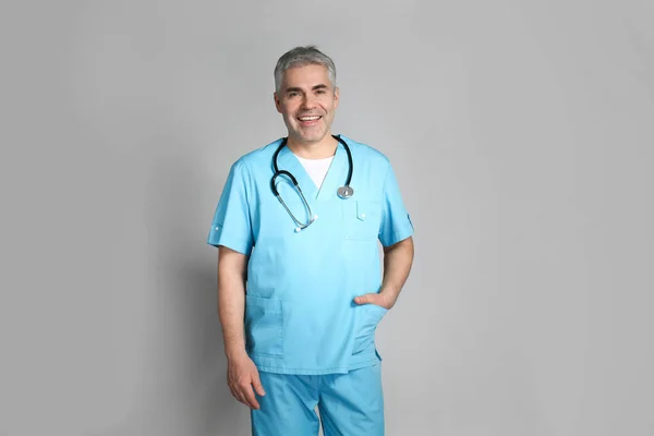 Mature doctor on grey background — Stock Photo, Image