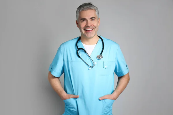 Mature doctor on grey background — Stock Photo, Image