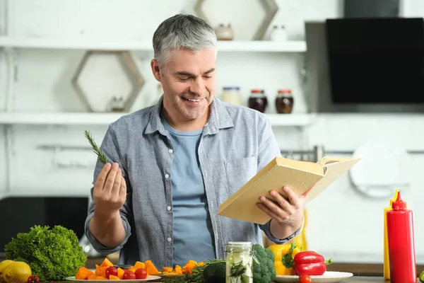 Mature man cooking dinner at home — Stock Photo, Image