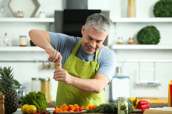 Mature man cooking dinner at home — Stock Photo, Image