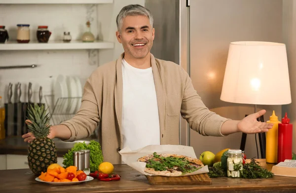 Mature man cooking tasty pizza at home — Stock Photo, Image