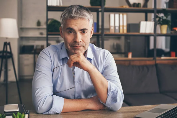 Volwassen man zit aan tafel in kantoor — Stockfoto