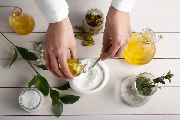 Mujer preparando cosmética natural sobre mesa blanca — Foto de Stock