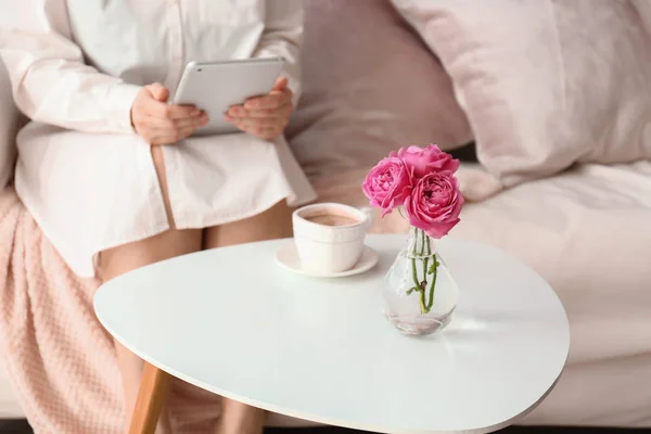 Junge Frau benutzt Tablet-PC am Tisch mit Tasse Kaffee zu Hause — Stockfoto